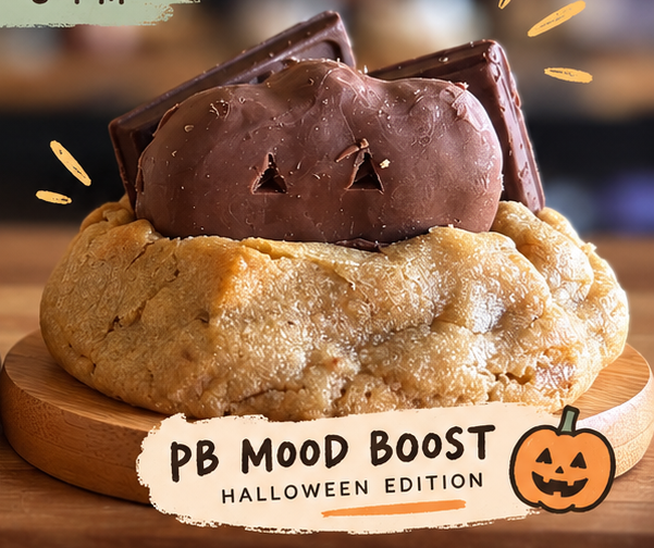 Peanut butter cookie with pumpkin Reese's Cup with dark chocolate chip and milk chocolate chip on wooden plate