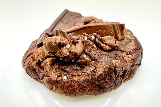 Dark chocolate cookie with chocolate pieces on a white background